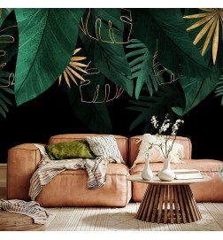Fototapeet - Jungle and composition - motif of green and golden leaves on a black background